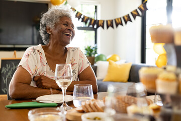 Elderly woman laughing joyfully at home during festive celebration with family