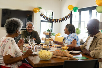 African American family celebrating at home, enjoying food and conversation together