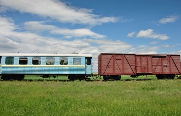 passenger and freight car of an old narrow gauge railway train in the countryside