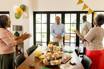 Celebrating birthday, family clapping and smiling with cupcakes and decorations