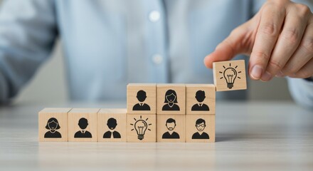 Hand placing lightbulb block on top of blocks with people icons.