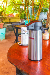Coffee dispenser on wooden table on tropical Holbox island Mexico.