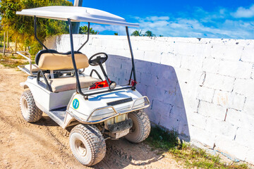 Golf cart buggy cars carts muddy street village Holbox Mexico.