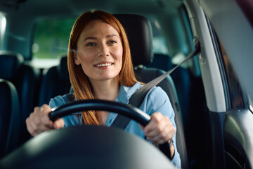 Happy businesswoman driving car.