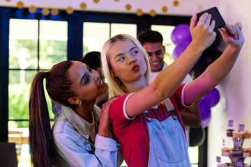 Friends taking selfie at birthday party, smiling and enjoying celebration together
