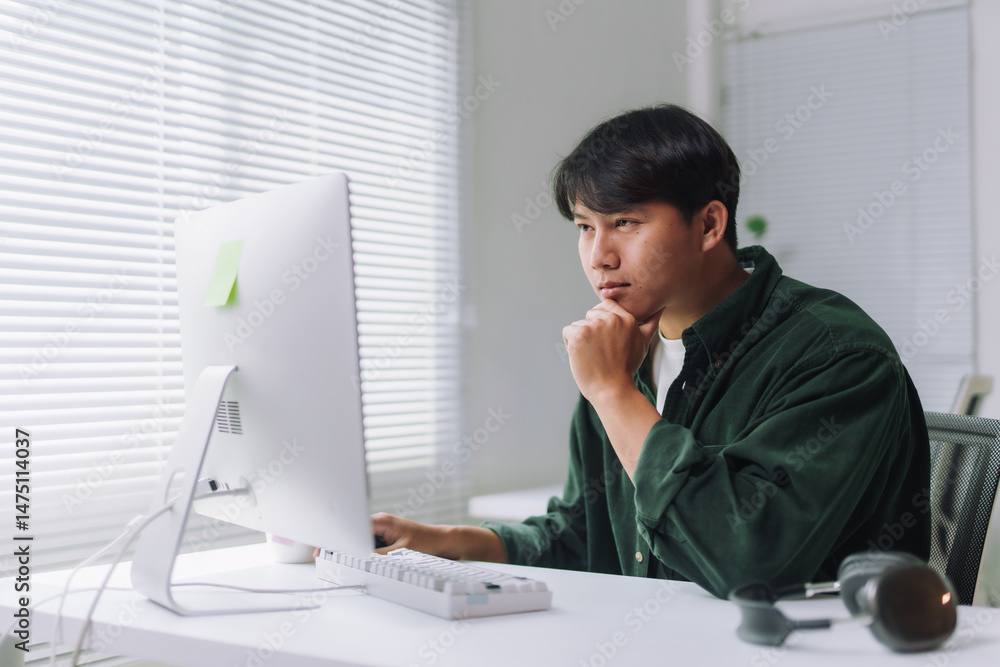 Poster young asian man working intently on a computer in a modern, bright office, focusing on coding and pr