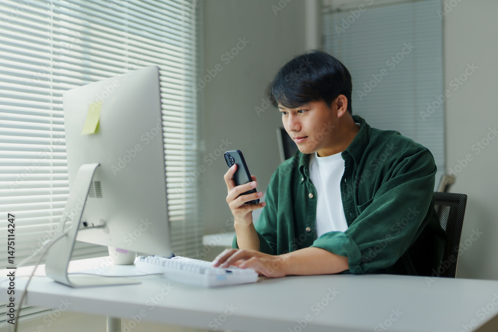 Poster young professional managing projects and multitasking using smartphone and computer in home office