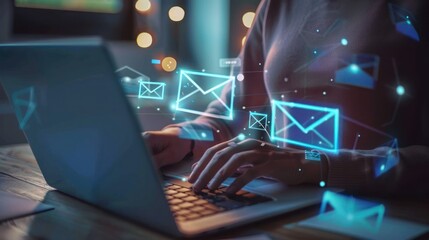 A person is typing on a laptop with a glowing screen that has many emails on it