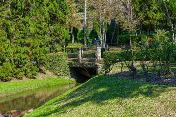 colorful flowers blooming and wooden bridge in garden and lake,rest and pathway near road,springtime..