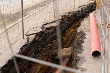 Repair of sewage heating systems or electricity. A trench has been dug in the ground, from which a...