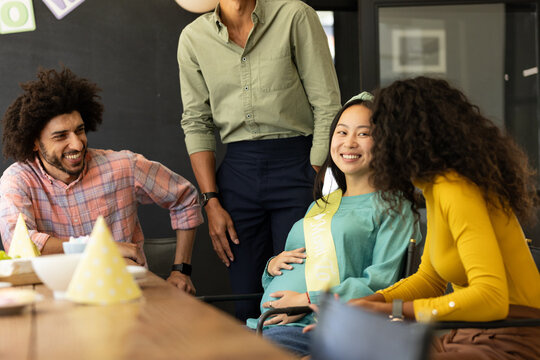 Colleagues celebrating baby shower at office, smiling and enjoying moment - Powered by Adobe