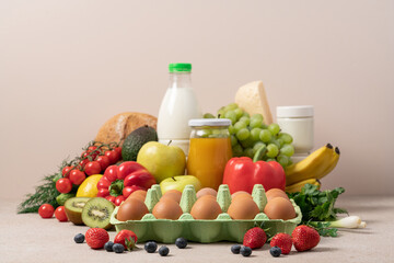 Grocery set of products. Eggs, milk, cheese, yogurt, fresh fruits, vegetables and berries on beige...