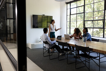 Business team discussing strategy in modern office with large windows