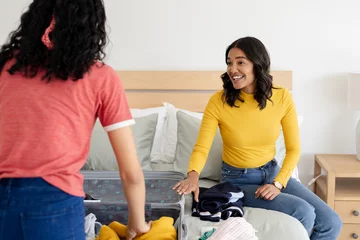 Gordijnen Mother and daughter packing suitcase on bed, preparing for family trip © WavebreakMediaMicro