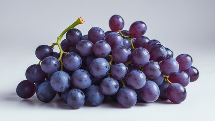 Fototapeta premium Juicy blue grapes bunch isolated on a white background with a wet texture