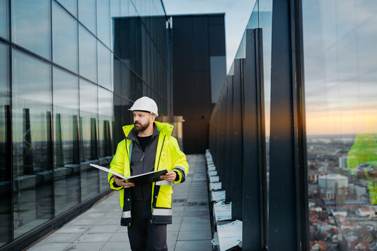 Engineer overseeing city construction project with blueprints in hand.