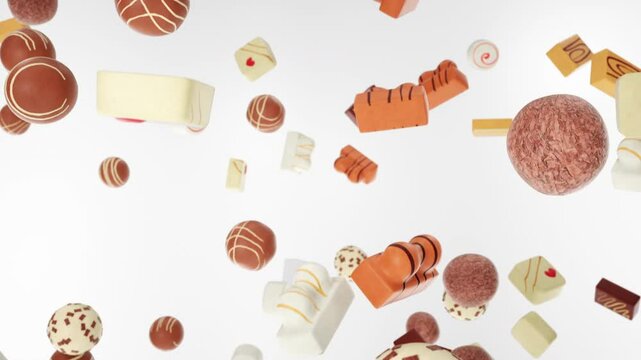 Close-up on pralines and chocolates falling down on a white background.