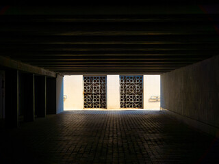 Light entering a dark underpass with metal gates