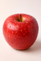 Red apple with water drops on white background showing freshness and natural sweetness