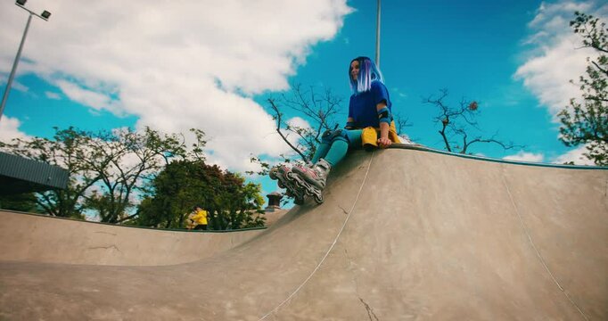 Teenager Girl with Blue Hair Chilling at Skate Park with Roller Blades. Training Hobby Active Lifestyle Youth Culture Concept