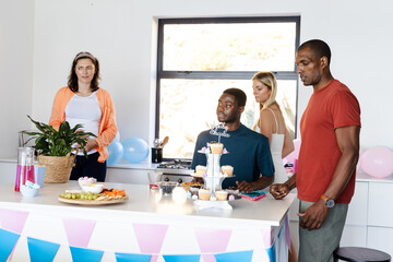 Celebrating birthday, diverse group enjoying cupcakes and decorations at home