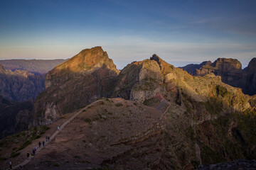 Exploring Pico do Arieiro in Madeira at sunrise with hikers on winding path amidst stunning mountain scenery