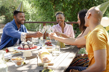 Celebrating outdoors, friends toasting with champagne at festive party together