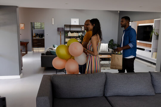 Friends arriving at home with balloons and gifts, preparing for celebration