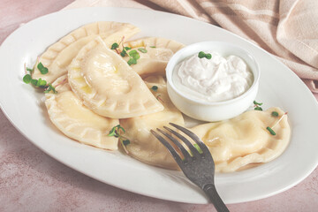 Traditional Georgian kvari dumplings, served with sour cream and herbs, close-up view, no people,