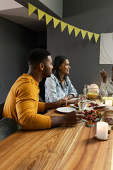 Friends enjoying dinner party with wine and laughter at cozy home gathering