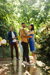 Dancing outdoors, African American couple at party with friends and balloons
