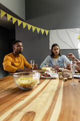 Friends enjoying dinner party with champagne and snacks at home