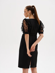 Pregnant girl model in stylish clothes on a colorless background in the studio.