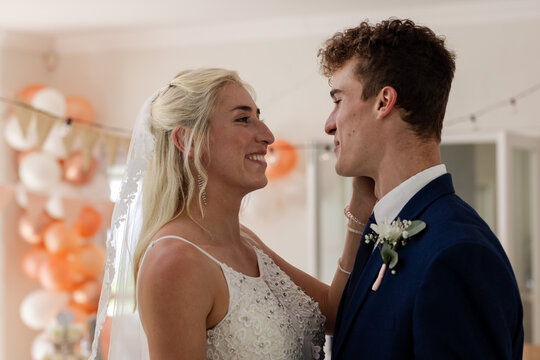 Bride and groom sharing joyful moment, smiling and embracing at wedding celebration - Powered by Adobe