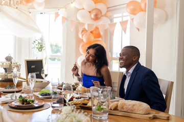 Smiling couple enjoying wedding celebration at beautifully decorated dining table