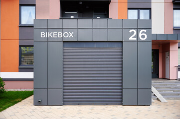 outdoor bike storage unit with closed shutter offers secure parking solution in urban setting....