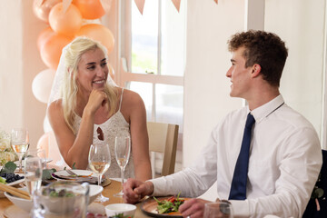 Bride and groom in joyful conversation during wedding reception, sharing smiles