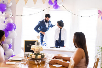 Family celebrating bar mitzvah with decorations and festive table setting