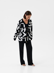 Fototapeta premium Pregnant girl model in stylish clothes on white background in studio.