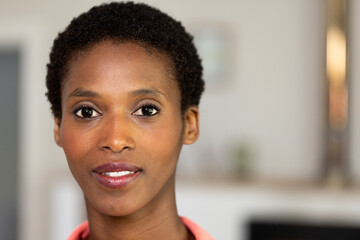Smiling woman with short hair looking confidently at camera indoors