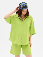 Pregnant girl model in stylish clothes on white background in studio.