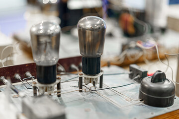 Vintage electronic components displayed in a workshop showcasing tube technology and circuitry from the mid-20th century