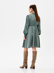 Pregnant girl model in stylish clothes on white background in studio.