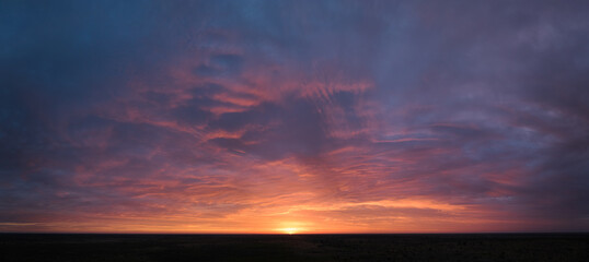 Ideal for sky replacement projects: Colorful sky at sunrise over the Central Kalahari Game Reserve in Botswana.  No obstacles, panoramic view, aerial shot.