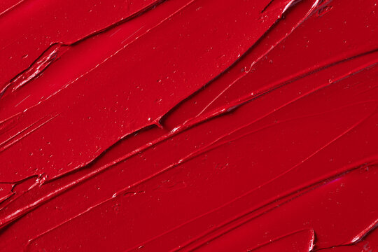 Rich red lipstick texture with smooth application and glossy finish, showcasing vibrant color and luxurious feel for beauty and cosmetic themes. Red lipstick background.
