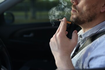 Man smoking cigarette in car, closeup. Space for text