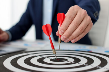 Man with dart aiming at dartboard while working indoors, closeup