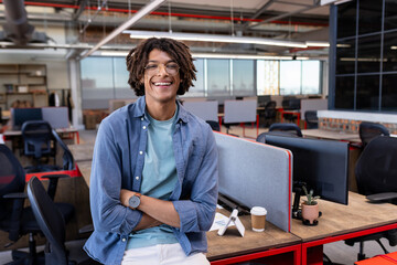 In office, African American man standing confidently, feeling relaxed and smiling