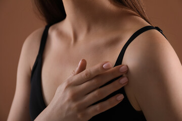 Woman with beautiful collarbone on brown background, closeup