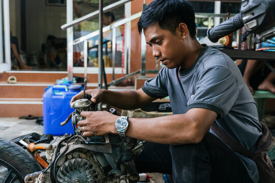 Mechanic working intently on motorcycle engine repair